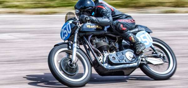 Image of a classic Norton bike being ridden on a race track