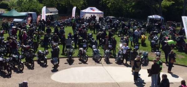 Image of a large group of motorbikes and their owners at a show.