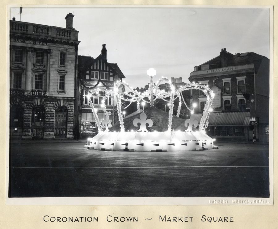A black and white photo of a huge crown lit up in the middle of Dover Market Square