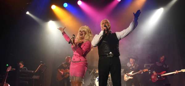 Image of Sarah Jayne on stage dressed in pink as Dolly Parton