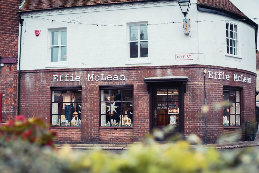 A corner shop with a sign saying 'Effie McLean' and Christmas decorations in the windows. 