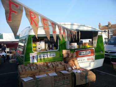 The green & yellow caravan selling Real Deal Roasters Coffee