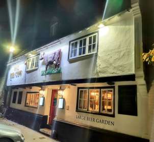 Exterior of the white washed walls of The Red Cow at night lit up