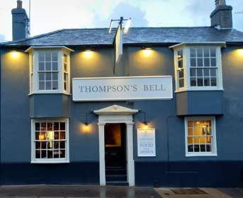 Front view of a blue painted pub called Thompsons Bell