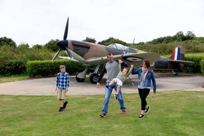 Family walking in front of the replica Spitfire at Battle of Britain Memorial