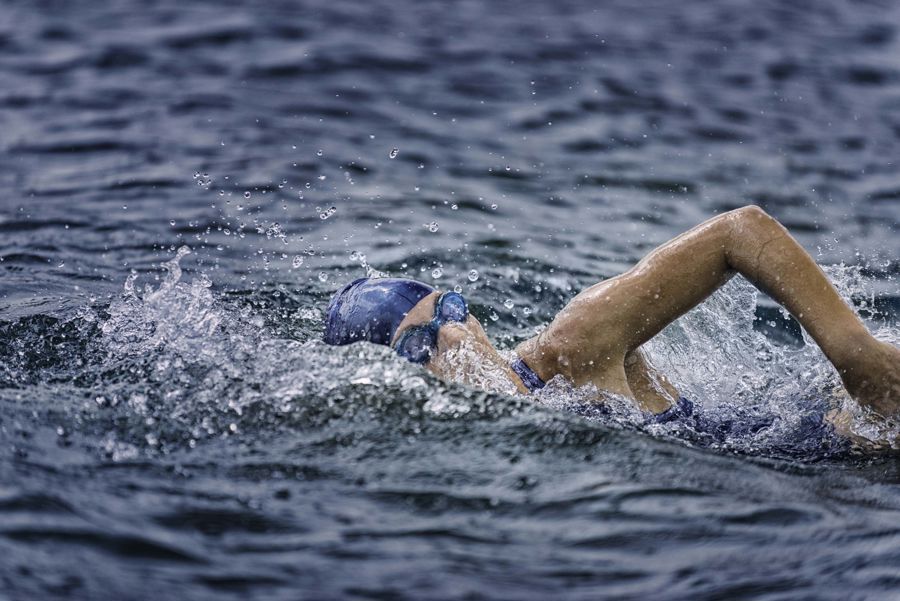 A swimmer in the sea with swimming cap and goggles