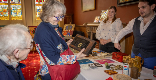 People looking at and handling artefacts