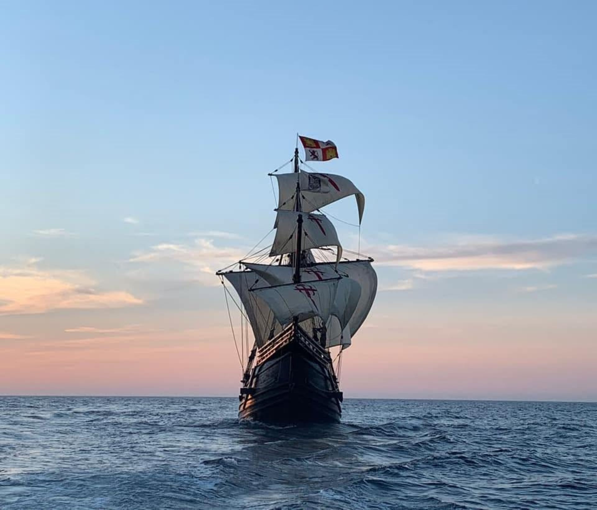 A wooden ship in full sail on the sea
