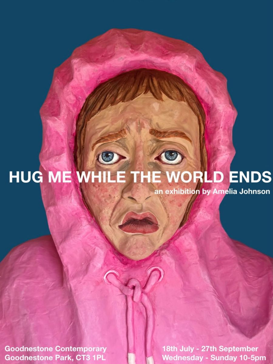 Papier mache sculpture of a head and shoulders wearing a pink hoodie.
