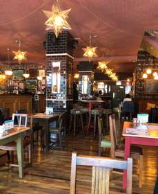 Interior of Acordo Lounge cafe bar with terracotta ceiling, star-shaped lights and wooden floor.