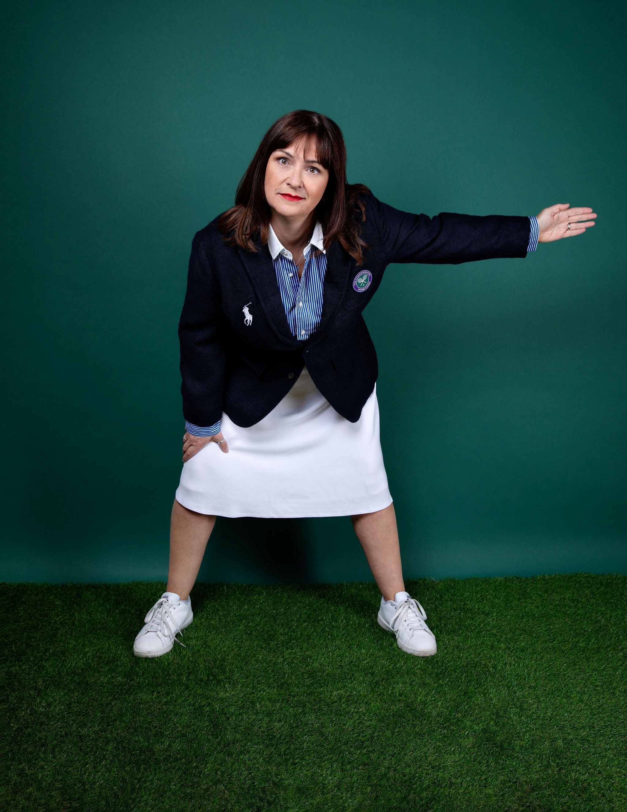 Pauline dressed as an umpire with a green background