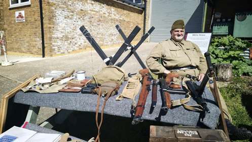 Re-enactor from WW11 sitting at a table with wartime equipment