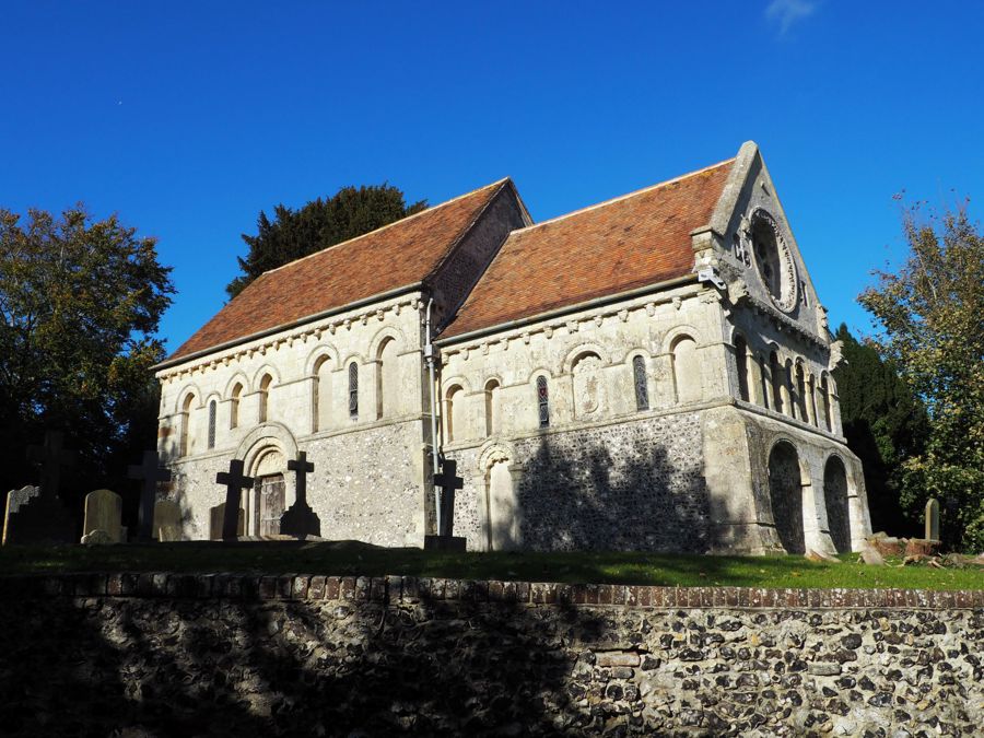 A pale stone church with red tiled roof