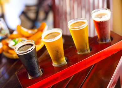 Four glasses of beer on a wooden board