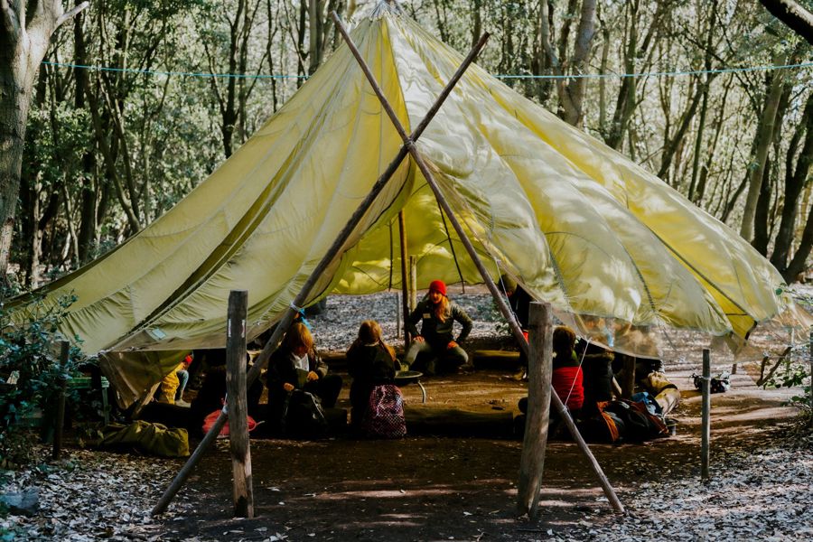 A large tent with a group of children and teacher inside