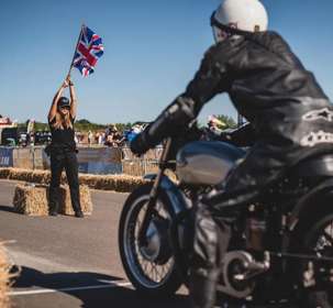 Woman holding flag in front of motorbikes