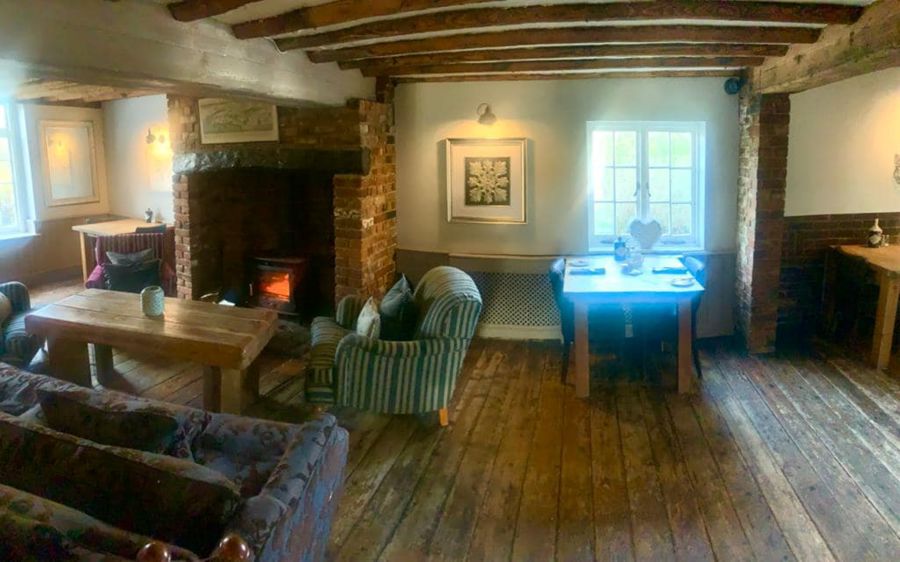 A warm and inviting log fire with comfy sofa & chairs
