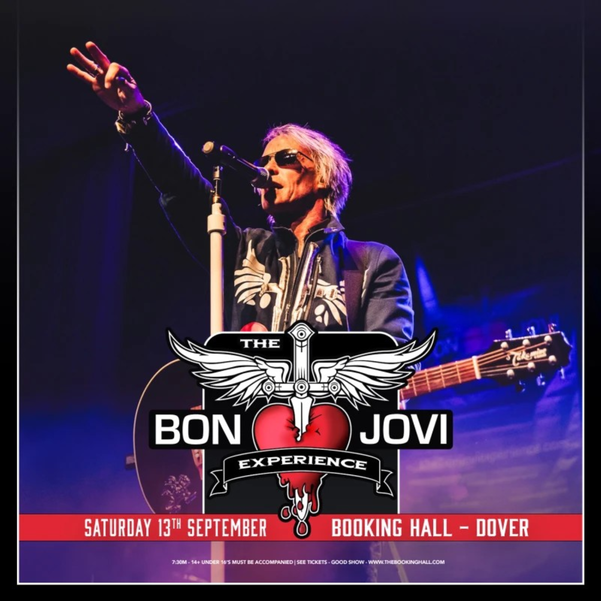 A male singer standing at a microphone with his hand in the air.