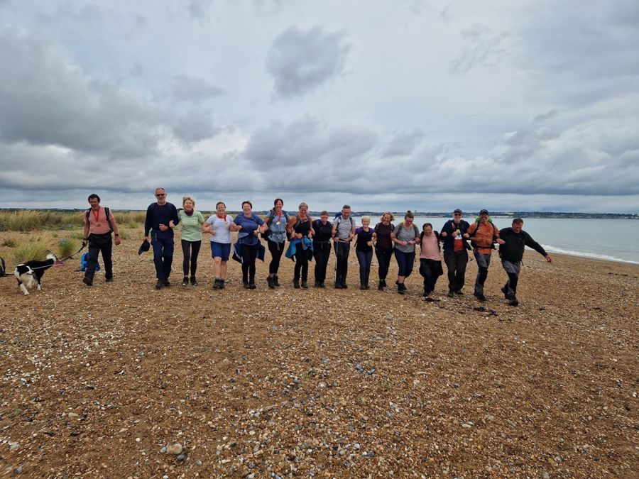 A line of people arm in arm on a beach