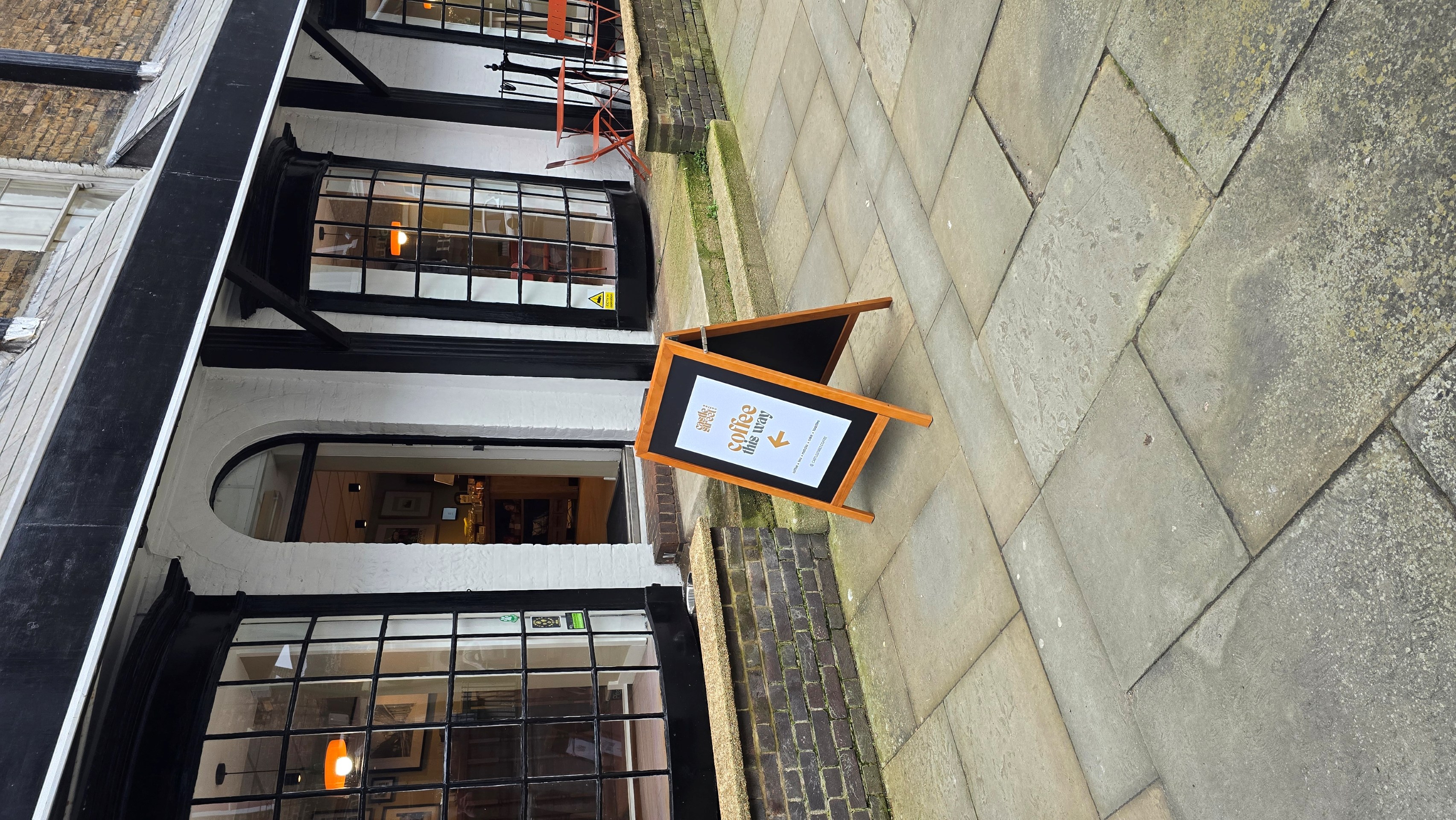 Front entrance door in between 2 bay Georgian windows with an A frame side on pavement