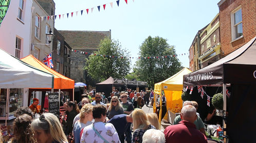 A bustling street market in the summer sunshine 