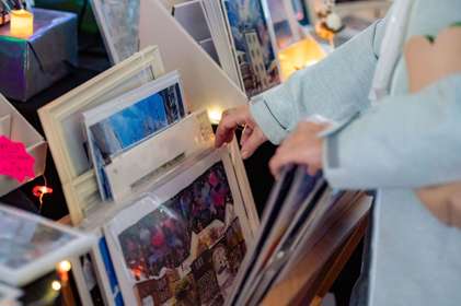 A person looking through art prints at a market