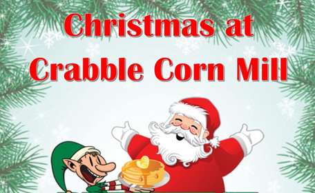 Cartoon picture of Santa Claus with an elf advertising Christmas at Crabble Corn Mill