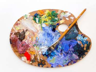 Artist's palette and brush covered with colourful paint