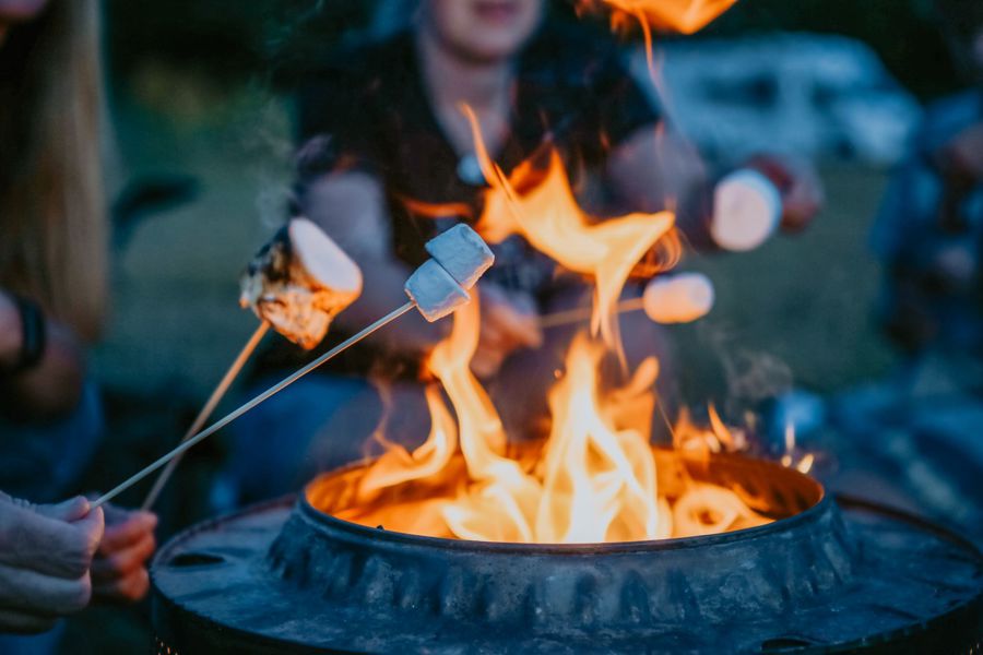 Toasting marshmallows over an open fire outdoors