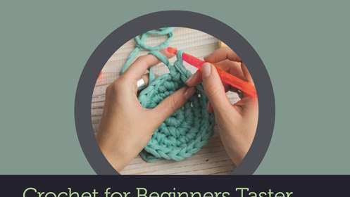 A person crocheting with teal yarn and red crochet needles 