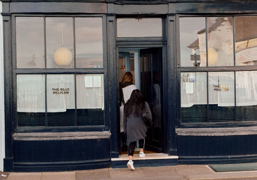 Two people walking into a restaurant.
