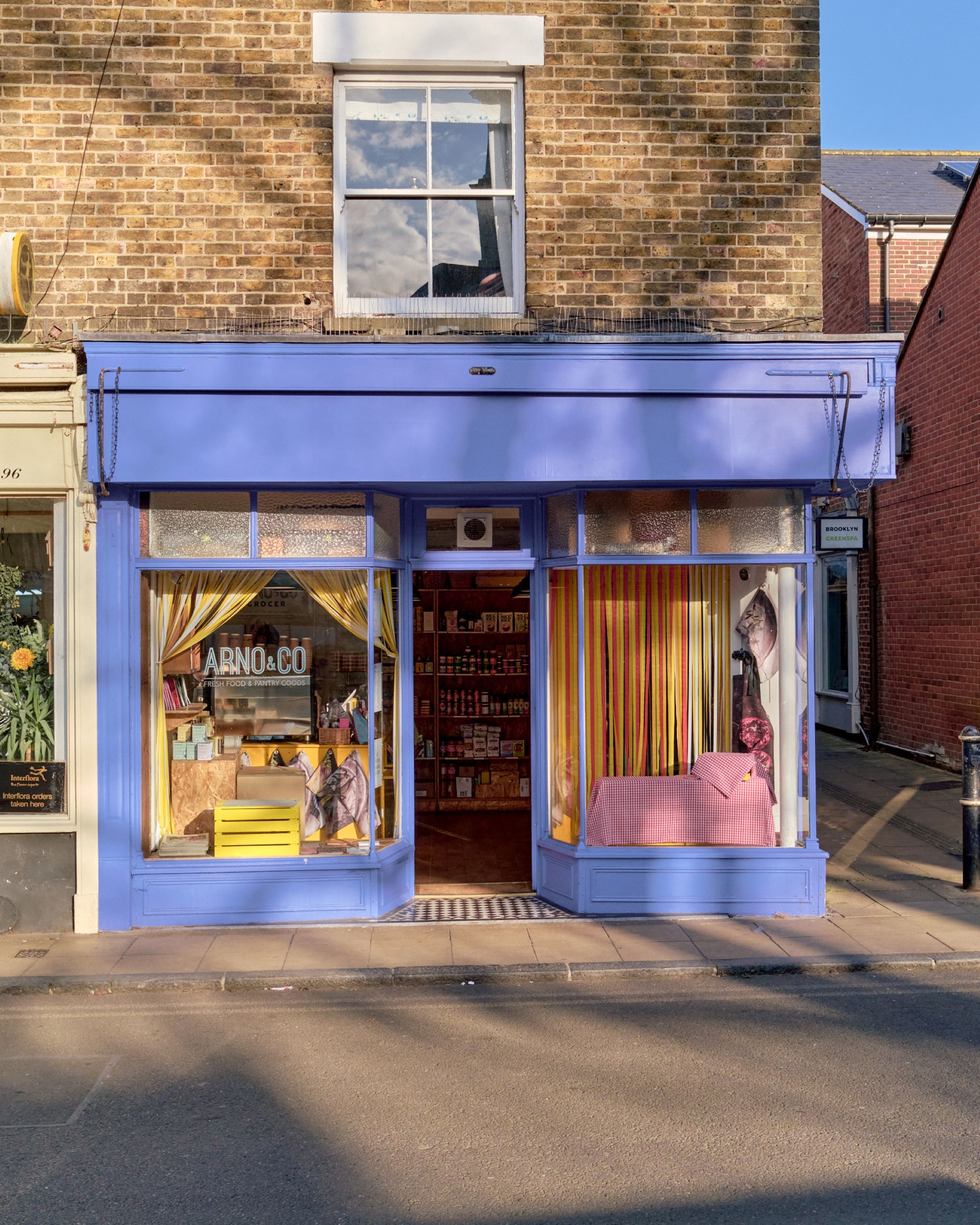 A delicatessen with colourful window displays and blue painted facade.