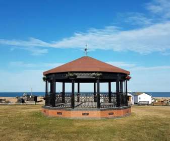 Deal Memorial Bandstand with blue sky and sea behind