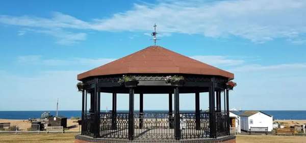 Photo of Deal Memorial Bandstand with blue sky and sea behind