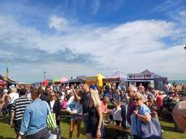 A crowd of people in front of food and drink stalls