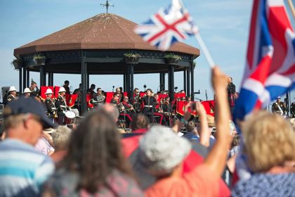 A band on Deal Memorial Bandstand and the crowd waving Union Jacks.