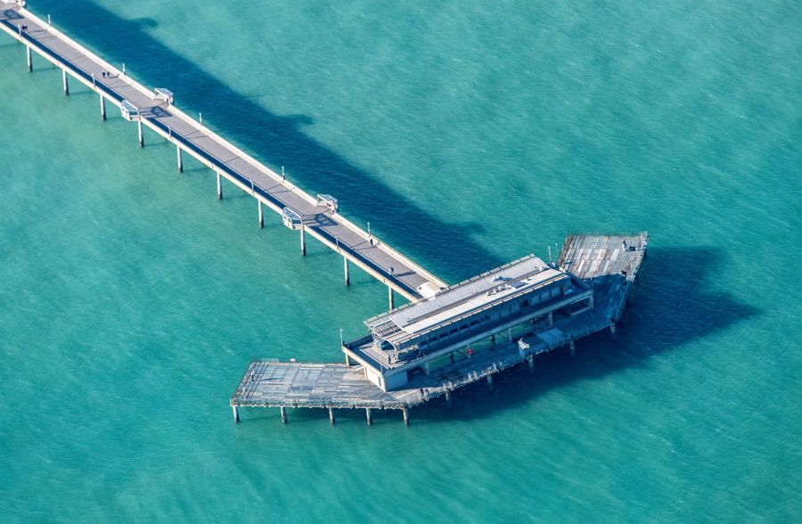 Aerial view of Deal Pier and a blue-green sea.