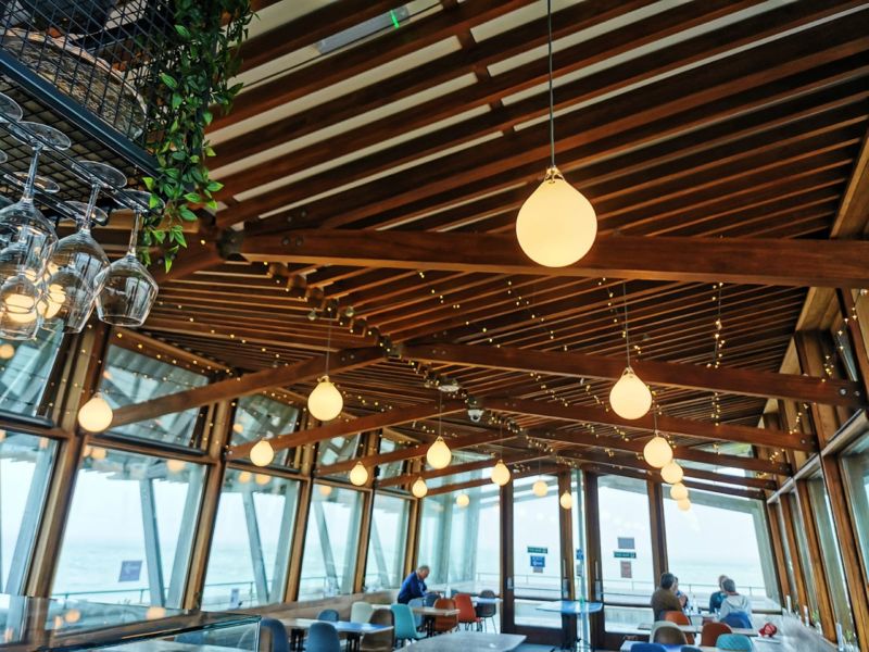 The interior of Deal Pier Kitchen showing the wooden roof struts