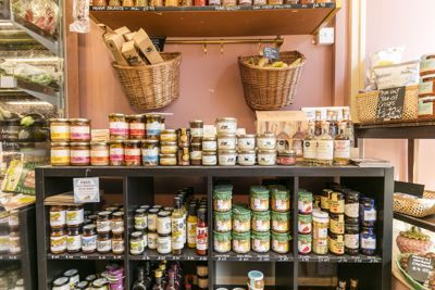 Shelves in a delicatessen loaded with interesting produce.