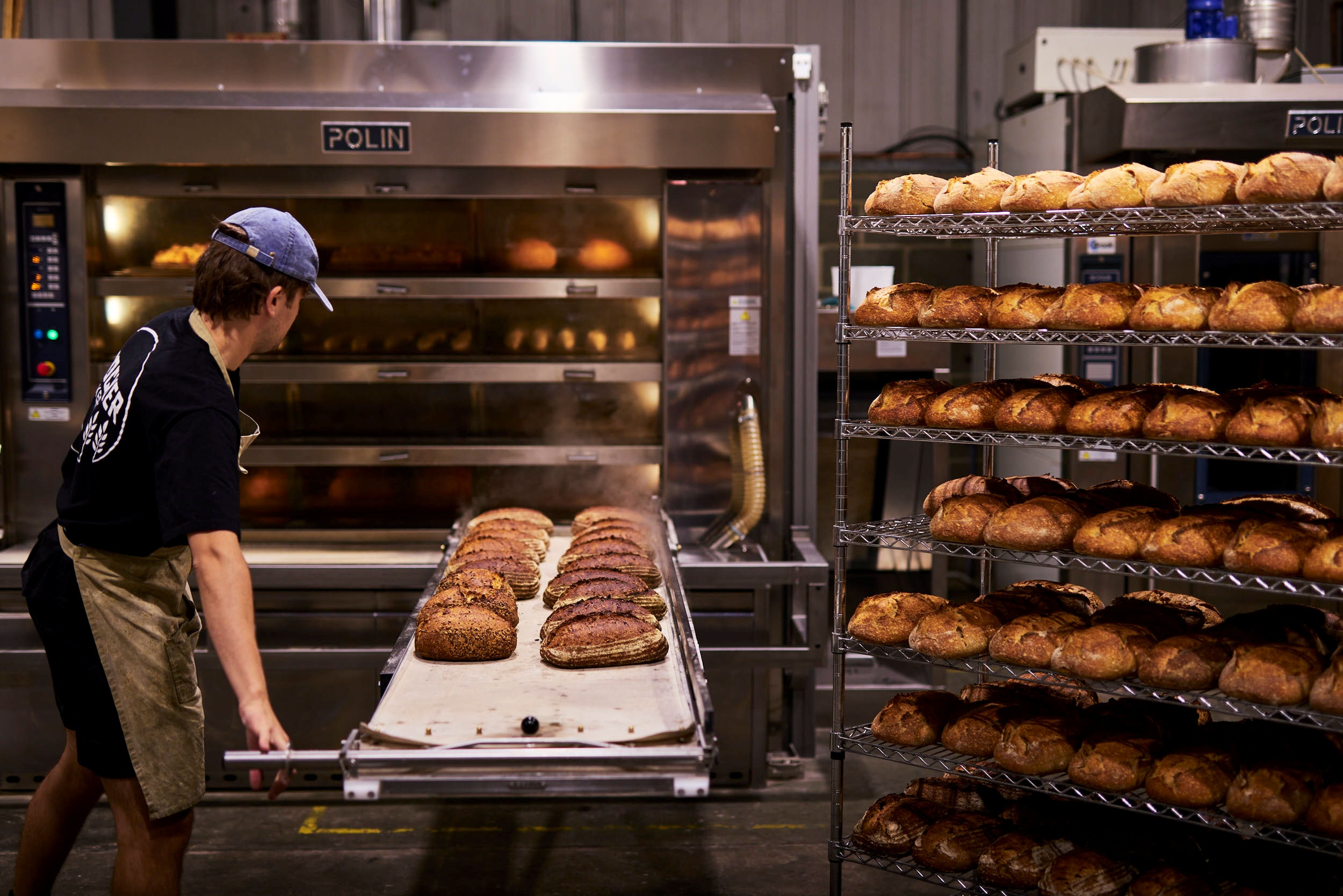 Freshly baked loaves being taken from the oven