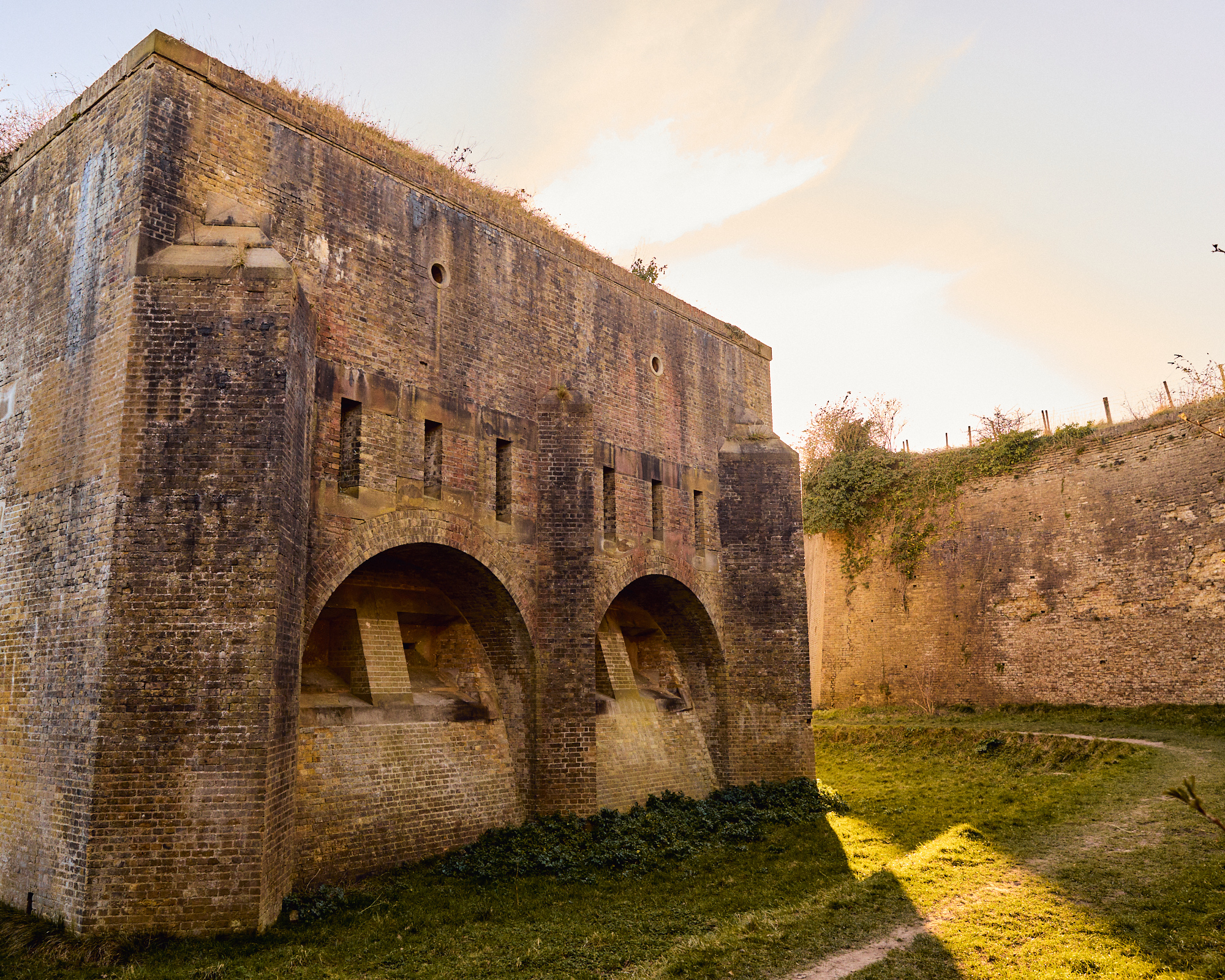 A ditch and high brick walls of a fort 