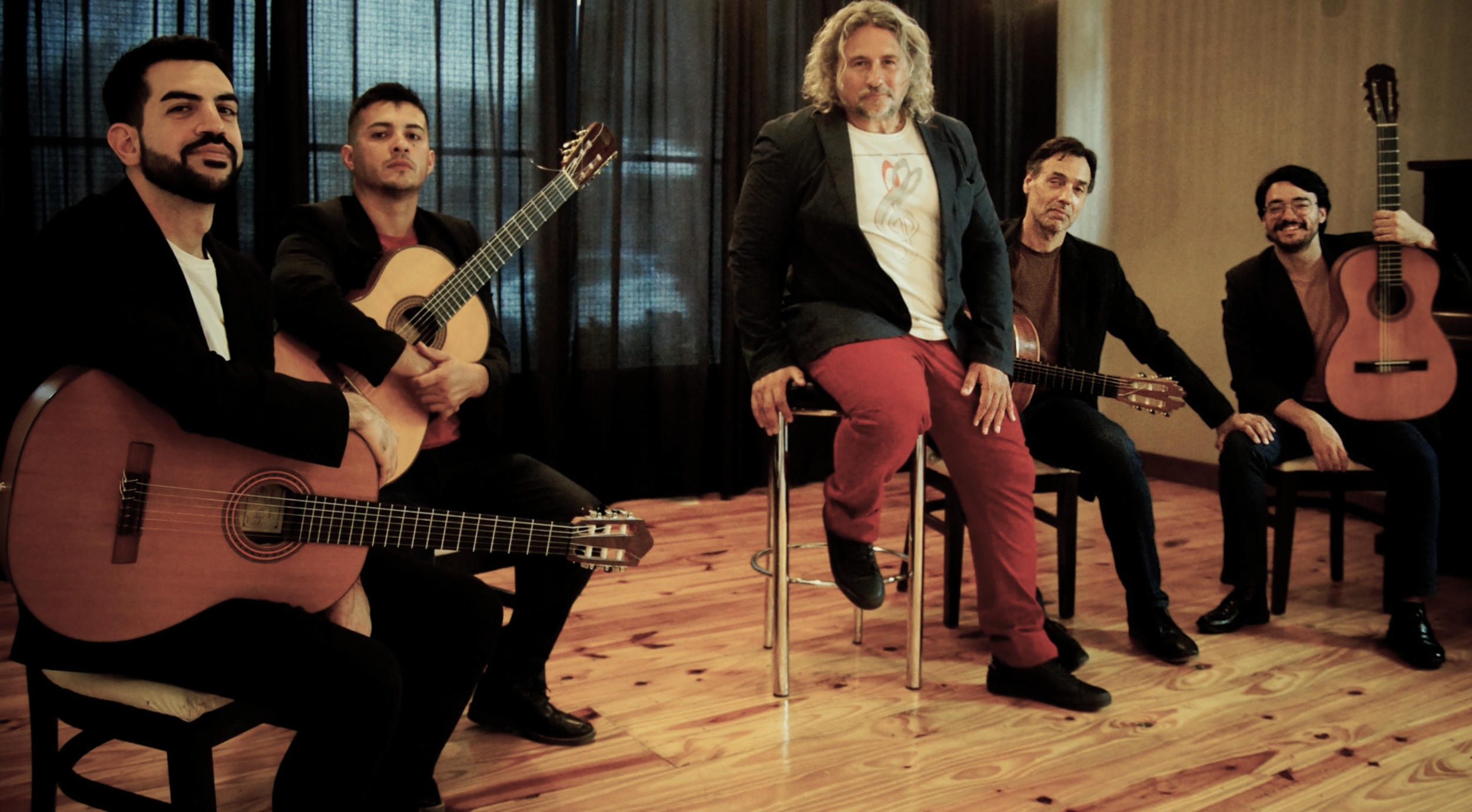 Members of the group sitting posing with their instruments