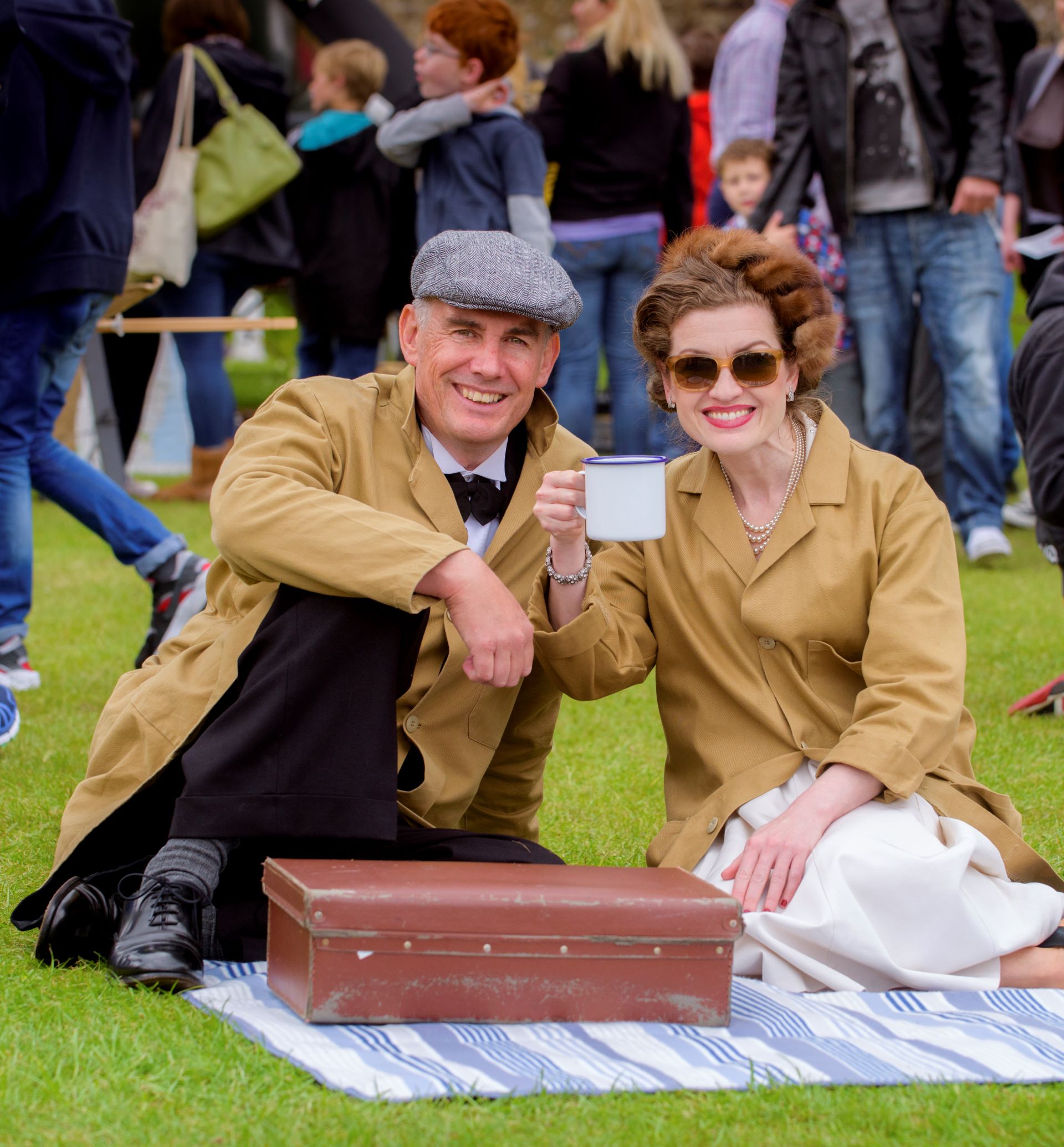 A couple in 1940s dress having a picnic.