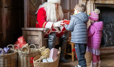 Two young children receiving gifts from Santa