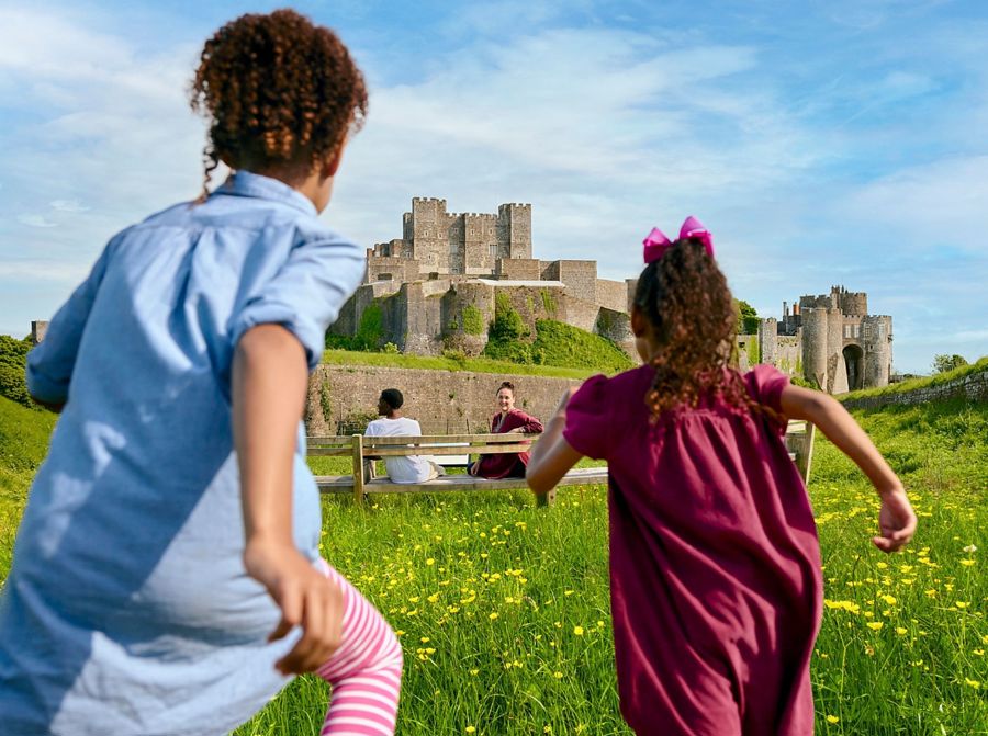 Two children running towards a castle 