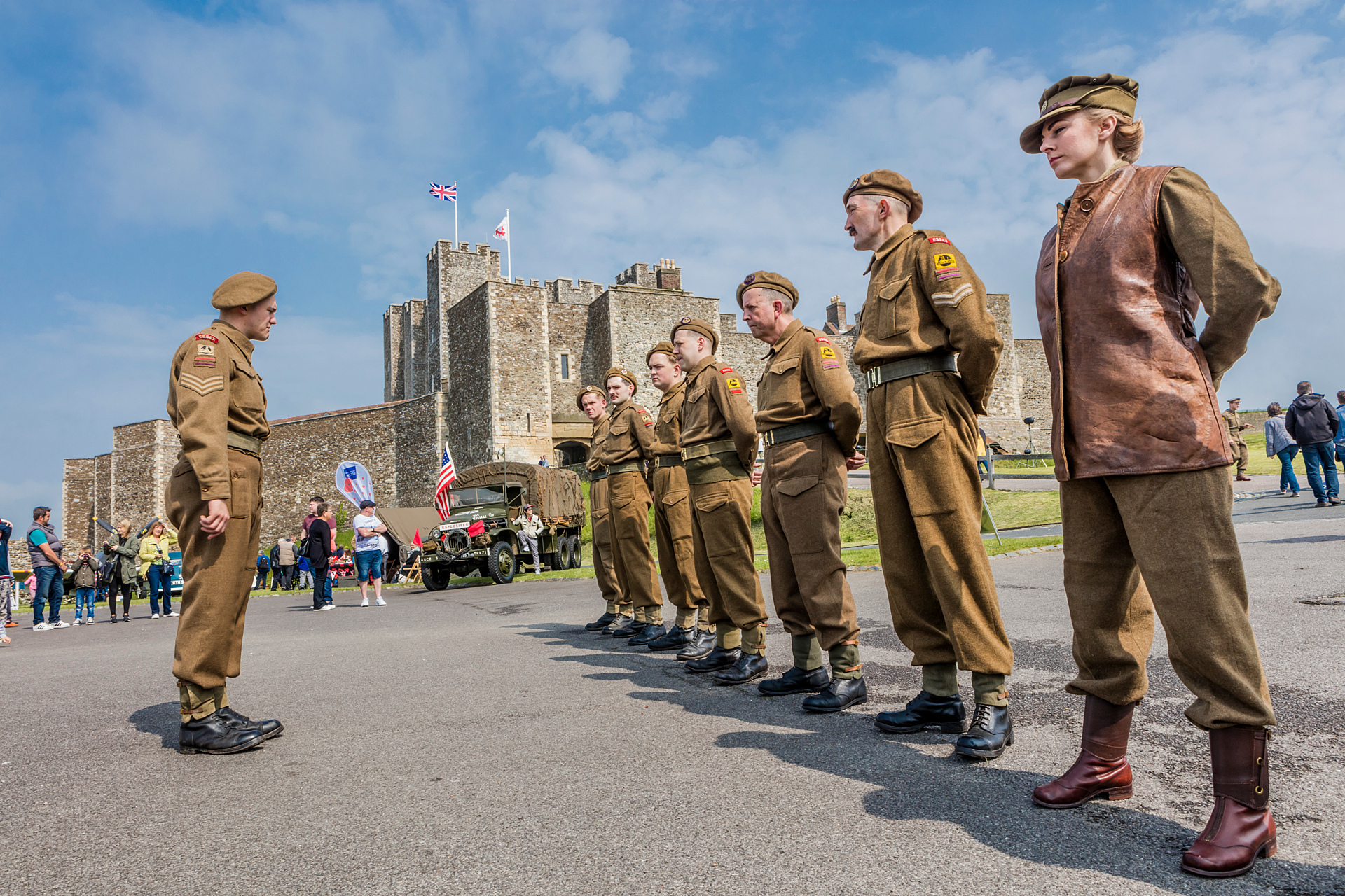 A line of soldiers in vintage uniforms with Dover Castle in the background