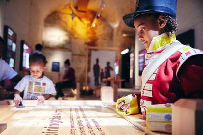 A boy dressed up as a soldier looking at a display