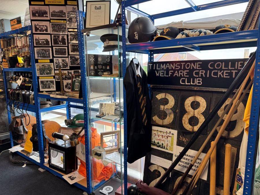 Cricket items and mining memorabilia on shelves