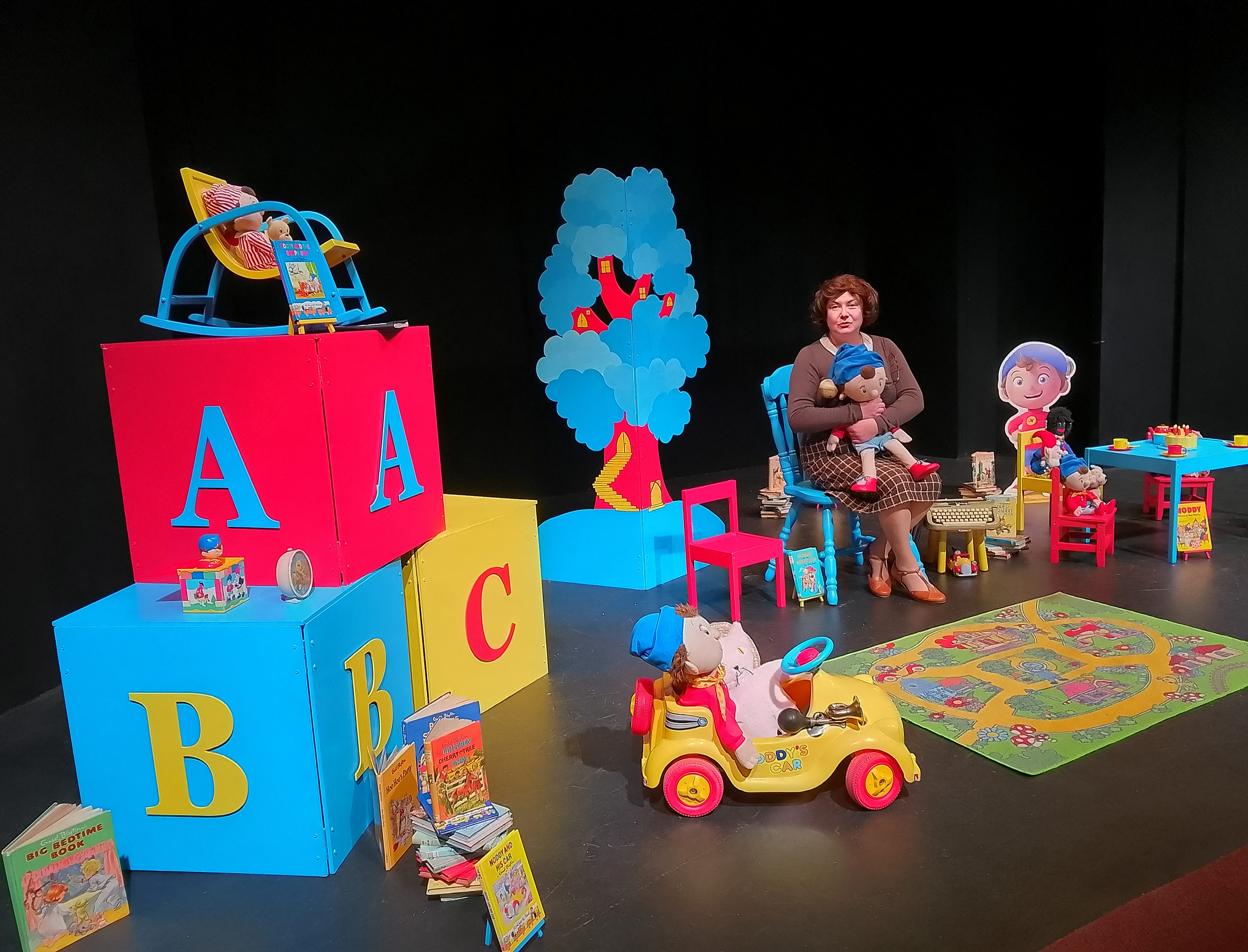 Children's playroom with a lady sitting holding a noddy doll