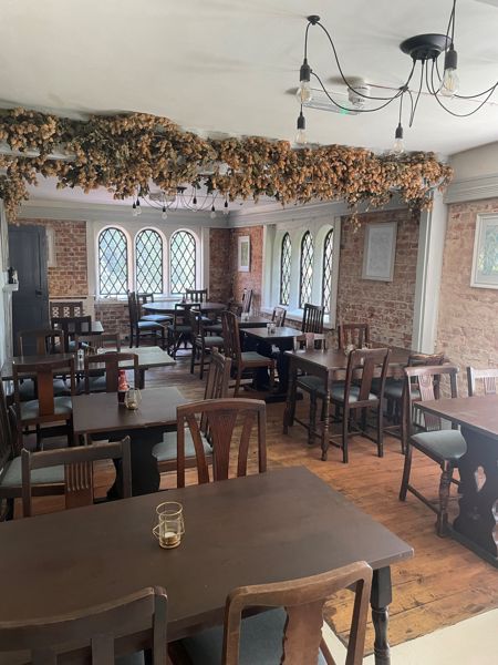 A beautifully presented dining room with dried hops hanging from a beam